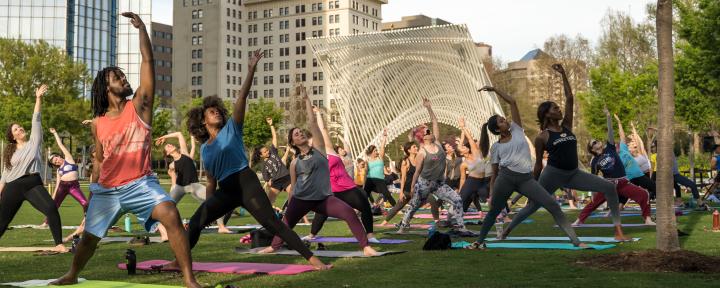 Large group practicing yoga on the Myriad Gardens lawn