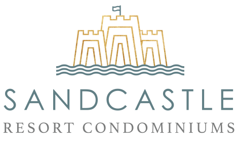 Line drawing of a sandcastle and some water in gold and teal. Under the drawing is a sans-serif font reading "Sandcastle" then under that a serif font reading "Resort Condominiums"