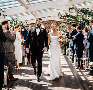 The bride and groom walk back down the aisle after exchanging their vows at Foxtail Barns, Staffordshire
