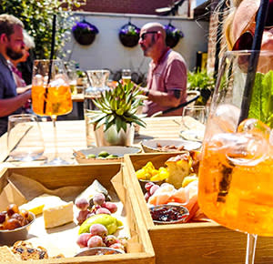 Image shows diners in the courtyard, bathed in sunshine, at Lowe's on Carter Street in Uttoxeter, Staffordshire