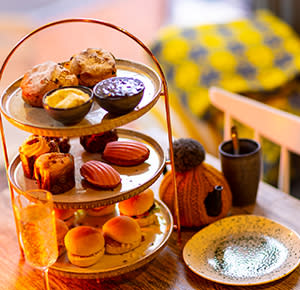 Image shows an afternoon tea with scones, cakes and sandwiches, as served at Pom's Kitchen in Lichfield