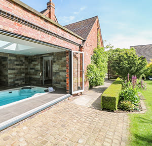 A look at the rear of The Chapel in Staffordshire, with its large hot tub and perfectly manicured gardens