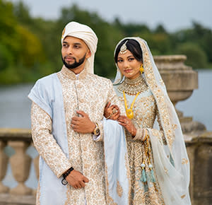 The bride and groom pose for their wedding photos beside the lake at The Trentham Estate, Staffordshire