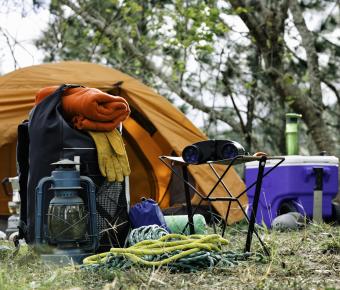 Camping gear in front of a tent in a forest