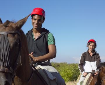 male and female riding horses on a trail