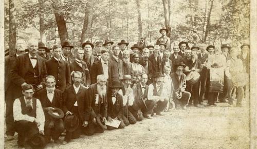 Black and white photo of men surrounding Lucy Higgs Nichols
