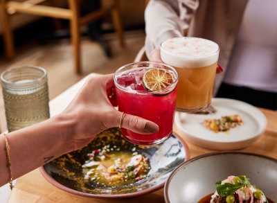 Two people dine and say cheers at the Michelin-starred Alma Fonda Fina restaurant in Denver, Colorado.