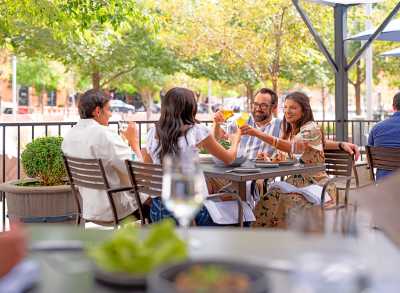 A group of people dine on the patio at Mercantile Dining & Provision in Denver, Colorado.