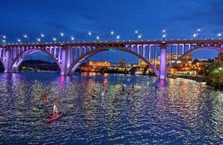 Lights reflect off of the Tennessee River as it flows past the Henley Street Bridge in Knoxville.