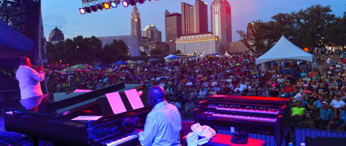 View from stage of band playing to crowd with skyline in background during Jazz & Rib Festival