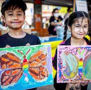 Boy and girl holding paintings of butterflies