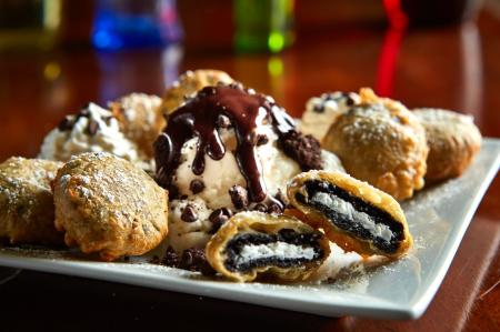 Deep-fried Oreo bites topped with ice cream and drizzled with chocolate syrup
