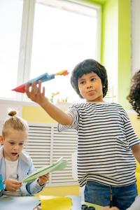 Kids play with paper airplanes