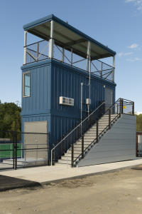 A navy blue field hockey storage room under a press box built by Southern Bleacher. 