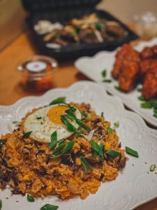 White plate with brown rice, and egg and garnishes offered at ArkanSeoul