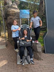 Three children posing on a Galactica ride test seat at Alton Towers.