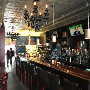 View inside antique wood countertops, chandeliers and bar inside The Olde Towne Tavern