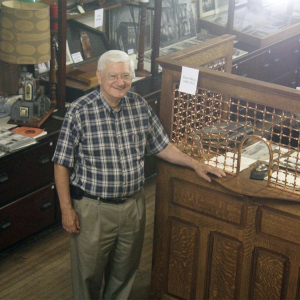 Local historian John Hertzler stands at an old-fashioned ticket booth in the Goshen Historical Museum in Goshen, Indiana.