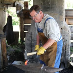 Blacksmith giving a live demonstration at Centennial Village Museum