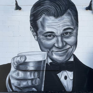 Leonardo DiCaprio raises a glass in a black-and-white mural on the side of Traveler's Taproom in Greenville, SC.