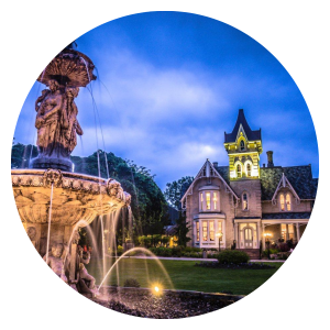 Gothic revival style fountain with mansion restaurant in background at dusk
