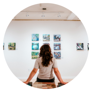 Circular image of person sitting on bench looking at gallery wall at Ingersoll Creative Arts Centre