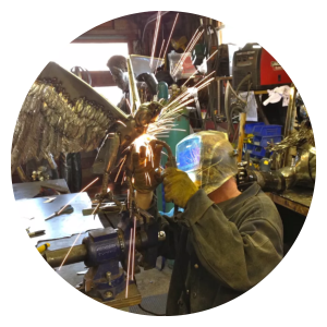 iron and welding artist working on metal bird sculpture