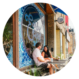 couple sitting at bistro table in front of early bird coffee