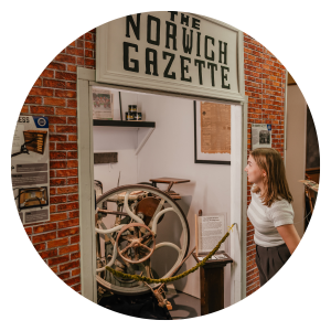 Guest looking at printing press display at Norwich Museum