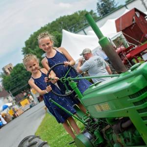 Little girls on a green tractor at the Kutztown Folk Festival