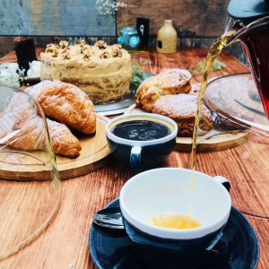 Tea is being poured and cakes and croissants ready to be served at Bolton Gate Cafe, Stoke-on-Trent, Staffordshire