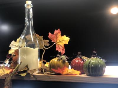 Glass colored pumpkins on a table with fall leaves from Threadz
