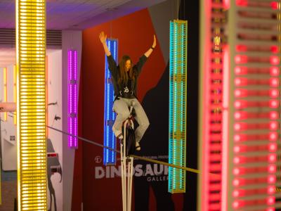 Woman riding high-wire unicycle at COSI