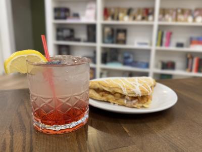 The Nook signature drink and turnover in front of bookcase