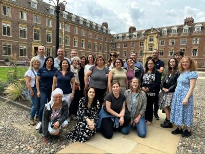 Group of men & women standing outdoors in the court of St Catharine's College, Cambridge