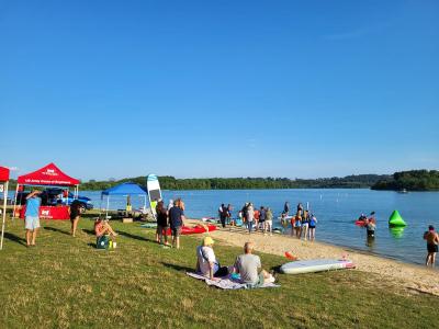 People at blue marsh with paddleboards and kayaks getting into the water