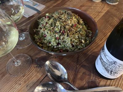 Bowl of Brussels Sprouts Salad on a table with two glasses of Ridgecrest wine.