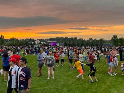 Hometown Celebration 4th of July event at M Health Fairview Sports Center with people enjoying the festivities and a band playing in the background