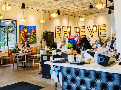 Inside Hope Breakfast Bar highlighting by "Believe" mural painted on wall while dinners await their order.