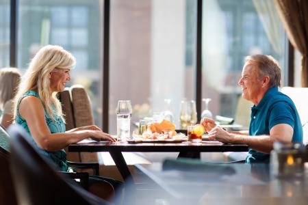 Couple eating dinner at Tavern in the Sky with a view of Lambeau Field in the background in Green Bay, Wisconsin.