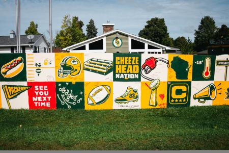 Painted fence with Green Bay and Wisconsin staples located on Lombardi Ave in Green Bay, Wisconsin.