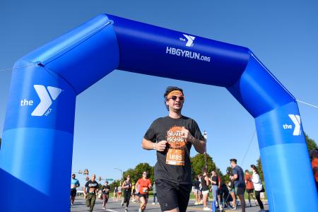 Runner crossing finish line at YMCA Troegs Hop Dash Race