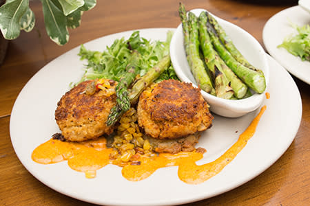 Deliciously cooked scallops sit on a bed of rice with a side of roasted asparagus at Manning's Restaurant.