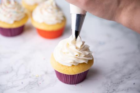 Decorating a cupcake with supplies from NC Paper Co. in Micro, NC.