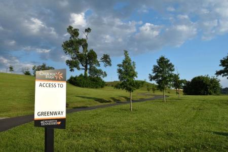 Manicured green grass lawns line the Knox Blount Greenway path in Knoxville, TN.