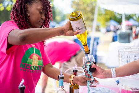 woman of color pouring wine at the music and wine festival at Towne Lake Park