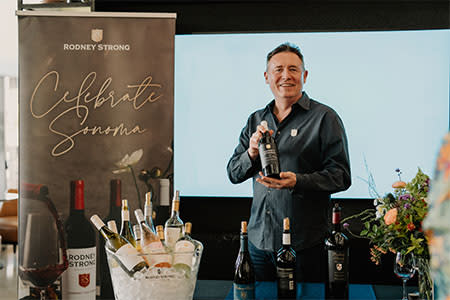 Flavors of the Peninsula participant. Man holding bottle of wine.
