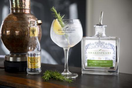 A gin and tonic next to a bottle of Stratford Gin by Shakespeare Distillery with a bottle of Fever Tree Tonic
