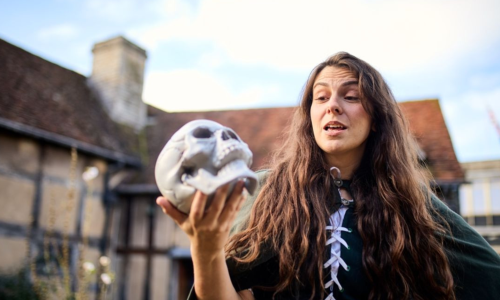 A woman holding a skull outside of Shakespeare's Birthplace