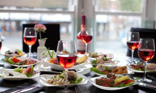 A table laden with plates of Greek meze and wines